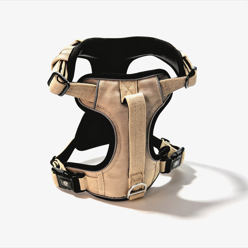 Beige dog harness with black accents on a white background