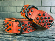 Top view of hand made orange leather dog collar with black fittings.